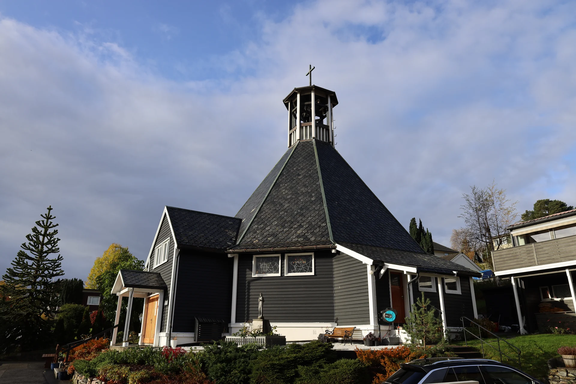 St. Sunniva kirke i Molde med klokketårn, kors og inngang
